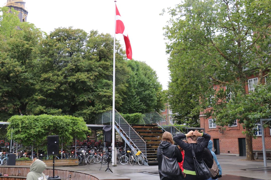 Flaget vejrer over en morgenfugtig skolegård